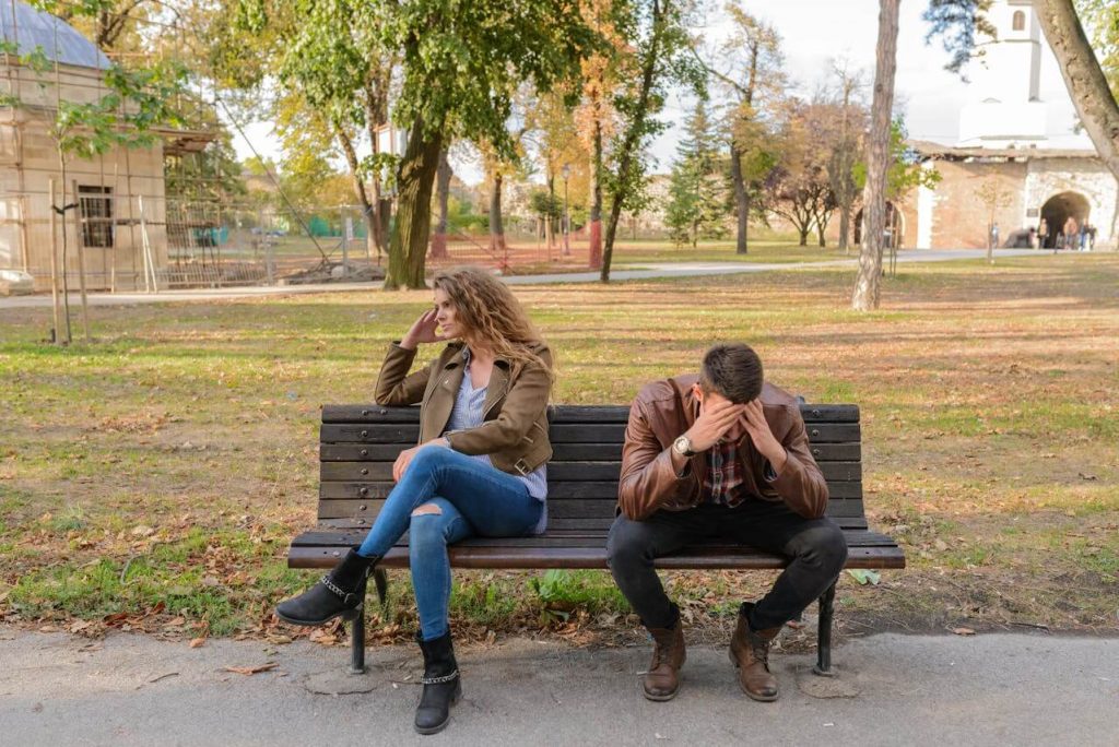 couple malheureux assis sur un banc